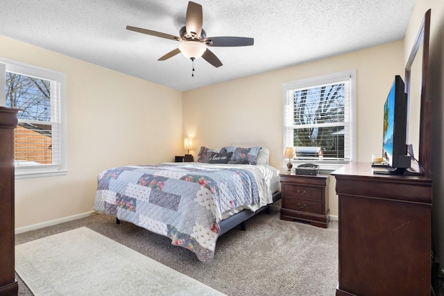 bedroom with a ceiling fan, light carpet, a textured ceiling, and baseboards