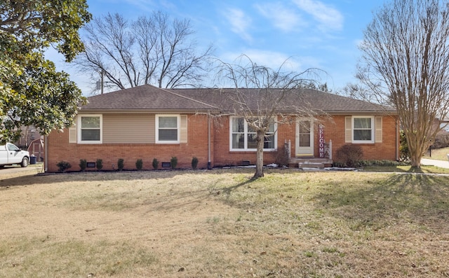 ranch-style home with roof with shingles, a front lawn, and brick siding