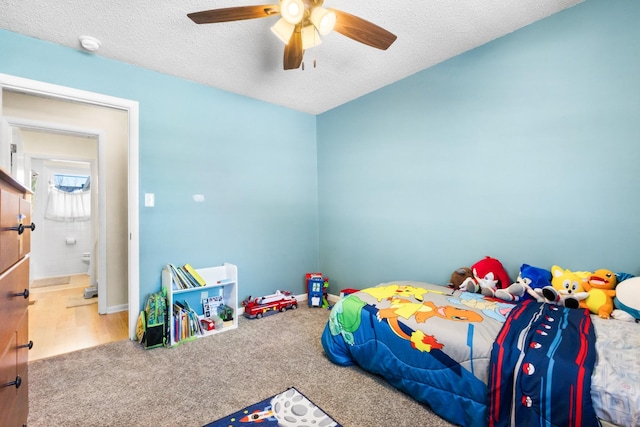 carpeted bedroom with ceiling fan, baseboards, and a textured ceiling