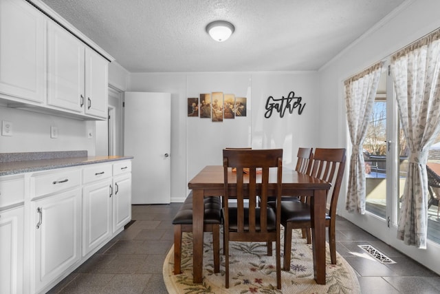 dining area featuring a textured ceiling and visible vents