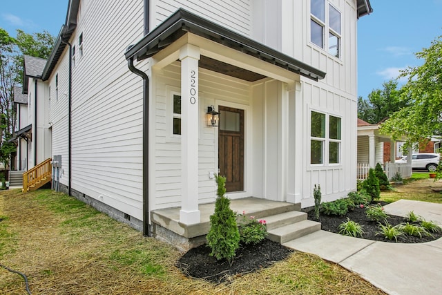 doorway to property with board and batten siding and crawl space