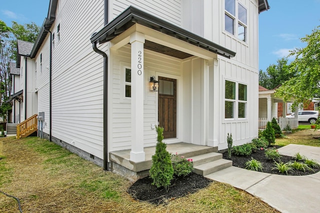 doorway to property featuring board and batten siding and crawl space