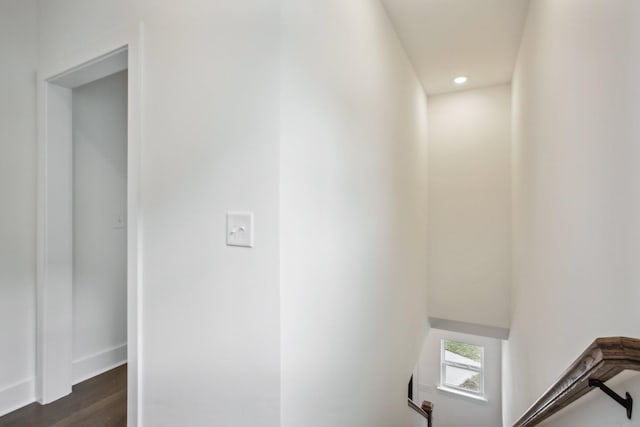 hall with dark wood-style floors, recessed lighting, baseboards, and an upstairs landing