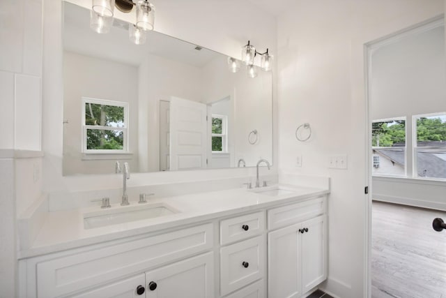 bathroom with a sink, baseboards, and double vanity