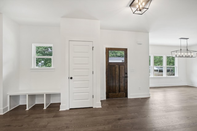 foyer entrance with baseboards, dark wood-style flooring, and an inviting chandelier