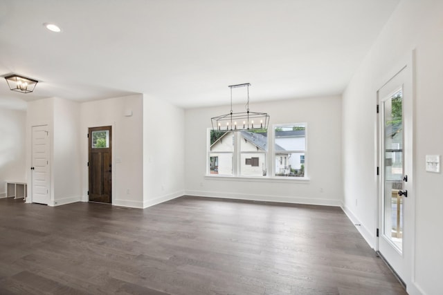 unfurnished dining area with a notable chandelier, dark wood-type flooring, recessed lighting, and baseboards