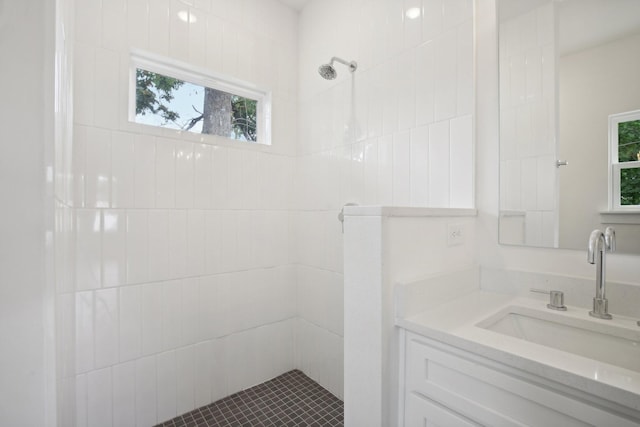 full bath with tiled shower and vanity