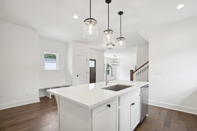 kitchen featuring dishwasher, light countertops, a sink, and an island with sink