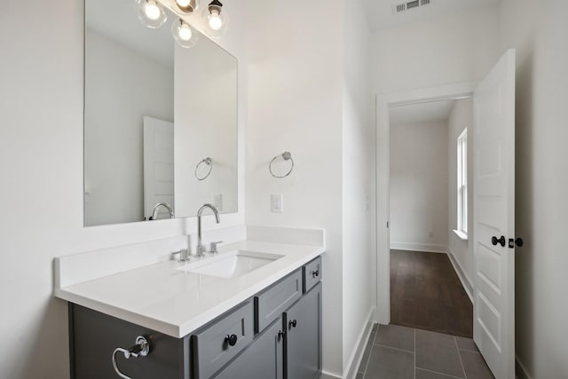 bathroom featuring tile patterned flooring, visible vents, baseboards, and vanity