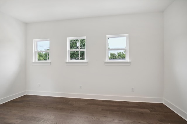 empty room featuring dark wood finished floors and baseboards