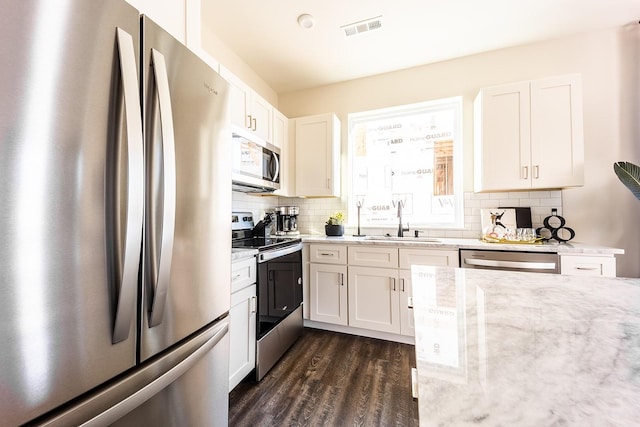 kitchen with appliances with stainless steel finishes, visible vents, and white cabinetry