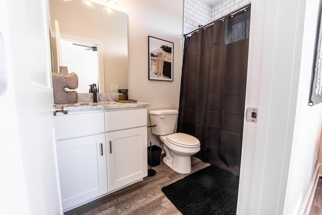 bathroom featuring toilet, wood finished floors, vanity, and a shower with curtain