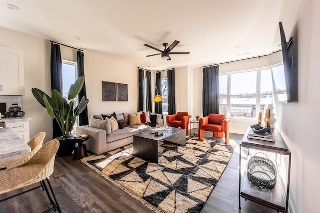 living room with dark wood-type flooring and a ceiling fan