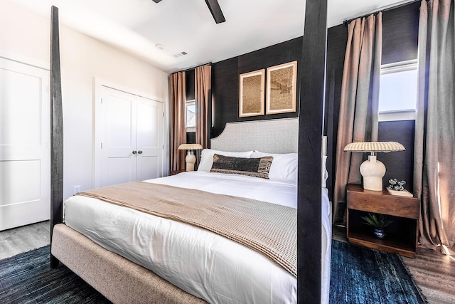 bedroom with ceiling fan, dark wood-style flooring, and a closet