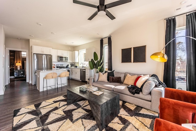 living room with dark wood-style floors and ceiling fan