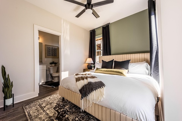 bedroom with ensuite bathroom, ceiling fan, dark wood-type flooring, and baseboards