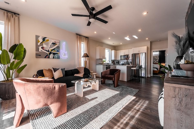 living room with dark wood-style floors, visible vents, a ceiling fan, and recessed lighting