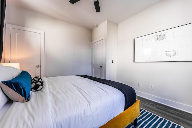 bedroom with dark wood-style floors, baseboards, and a ceiling fan