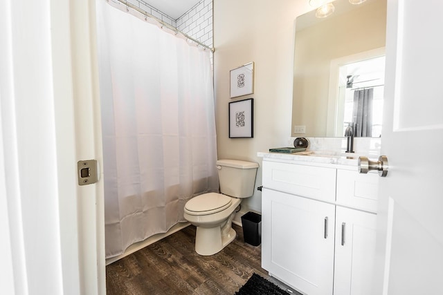 bathroom featuring toilet, shower / bath combination with curtain, wood finished floors, and vanity