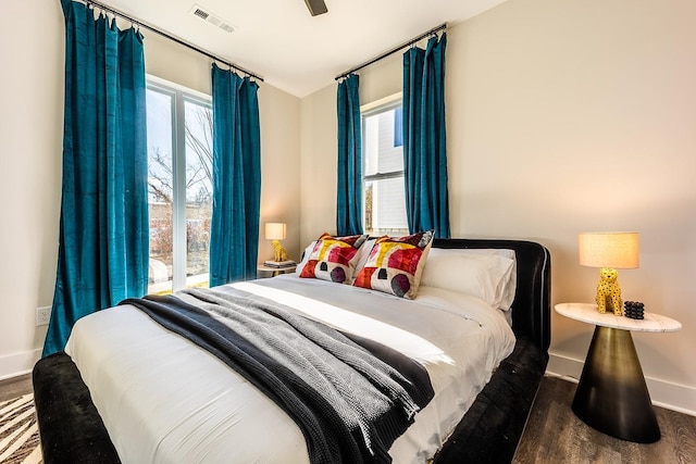 bedroom with baseboards, visible vents, and dark wood-type flooring