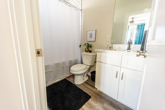 bathroom featuring shower / bath combo, vanity, toilet, and wood finished floors