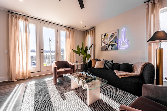 living room featuring a ceiling fan, baseboards, and wood finished floors