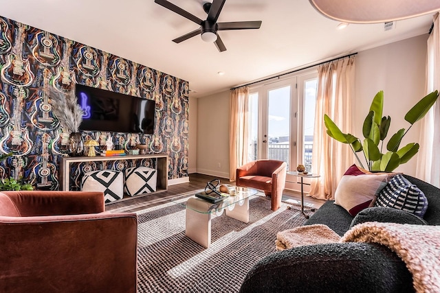 living room featuring a ceiling fan, visible vents, baseboards, and wood finished floors