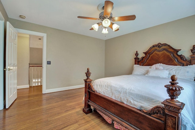 bedroom with a ceiling fan, baseboards, and wood finished floors