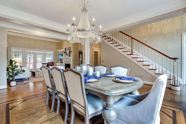 dining room with stairs, a warm lit fireplace, wood finished floors, and crown molding