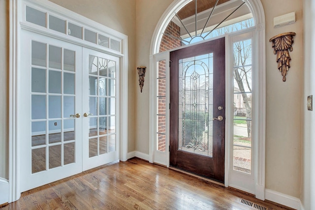 entryway featuring baseboards, visible vents, wood finished floors, and french doors