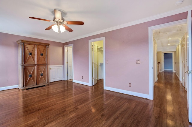 unfurnished bedroom with dark wood-style floors, ornamental molding, and baseboards