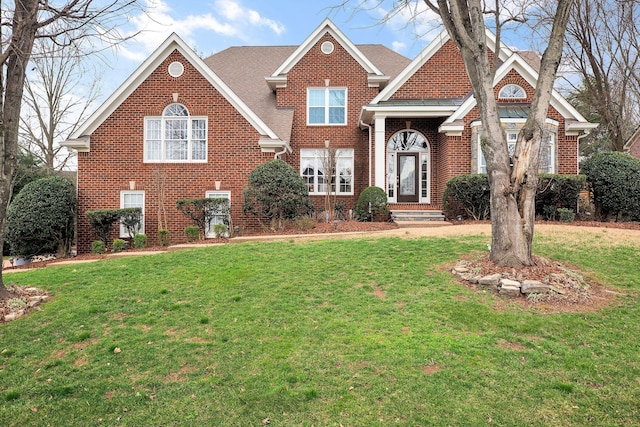 traditional-style home featuring brick siding and a front yard