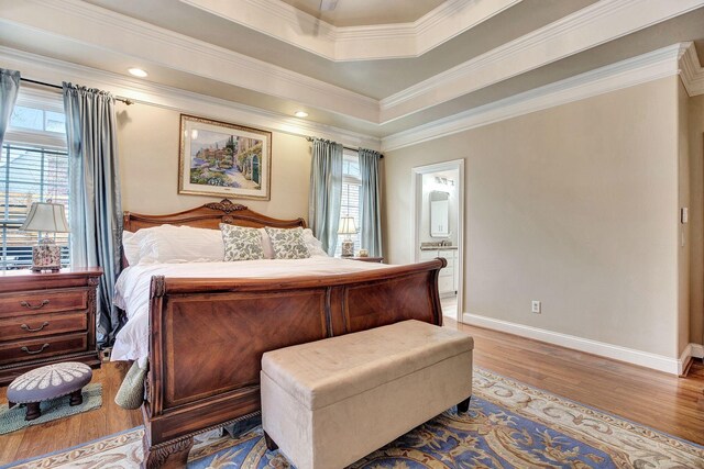 bedroom with light wood-style flooring, multiple windows, baseboards, and ornamental molding