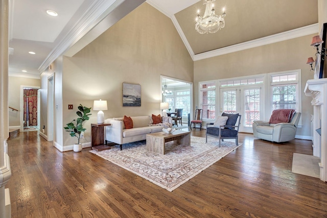 living area with dark wood-style floors, ornamental molding, baseboards, and a notable chandelier