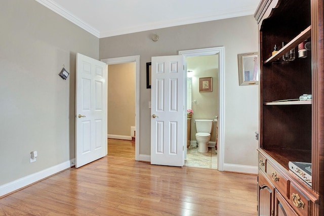 bedroom with ornamental molding, baseboards, ensuite bath, and light wood finished floors