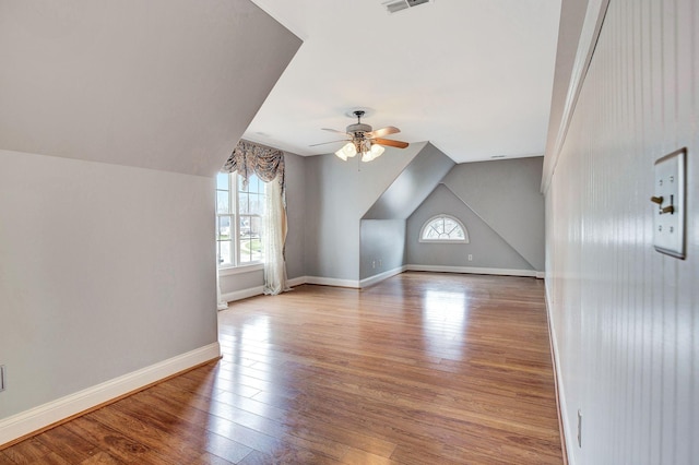 bonus room with lofted ceiling, visible vents, baseboards, and wood finished floors