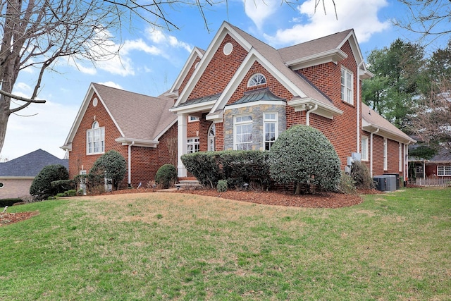 view of front facade featuring stone siding, a front yard, and brick siding