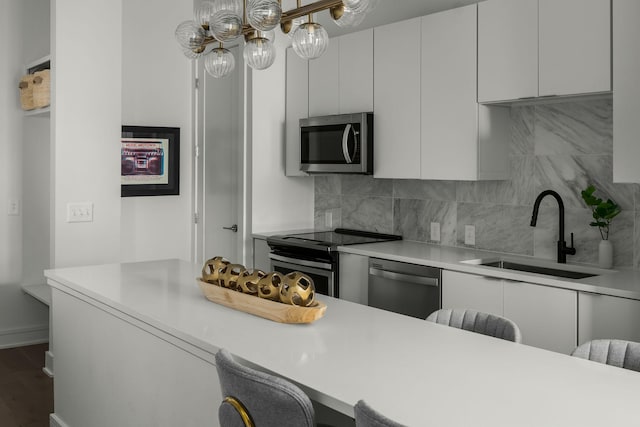 kitchen with stainless steel appliances, light countertops, and white cabinetry