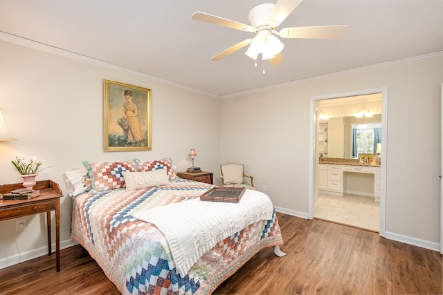 bedroom featuring ceiling fan, wood finished floors, baseboards, ensuite bath, and crown molding