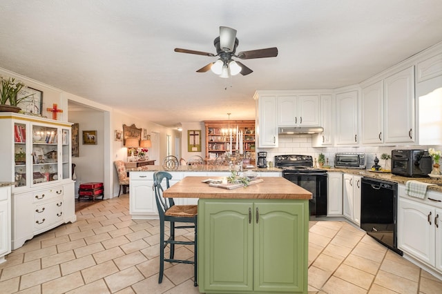 kitchen featuring a breakfast bar area, white cabinets, a peninsula, under cabinet range hood, and black appliances