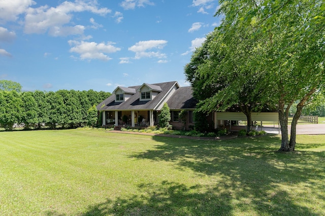 cape cod house featuring covered porch and a front lawn