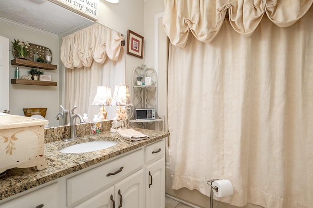 bathroom featuring crown molding, vanity, and a textured ceiling