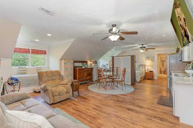 living room with light wood finished floors, visible vents, ornamental molding, a textured ceiling, and recessed lighting