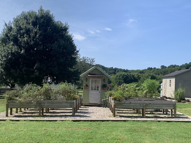 view of outbuilding with a garden and an outbuilding