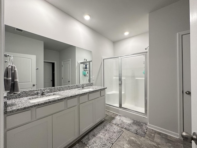 bathroom with double vanity, a sink, visible vents, and a shower stall