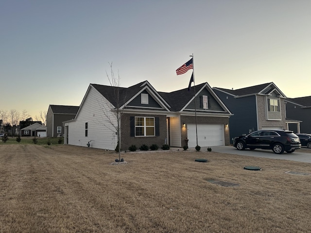 view of front facade featuring a garage, driveway, brick siding, and a front yard