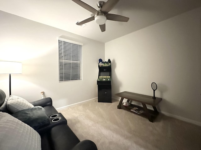 living area featuring carpet floors, baseboards, and a ceiling fan