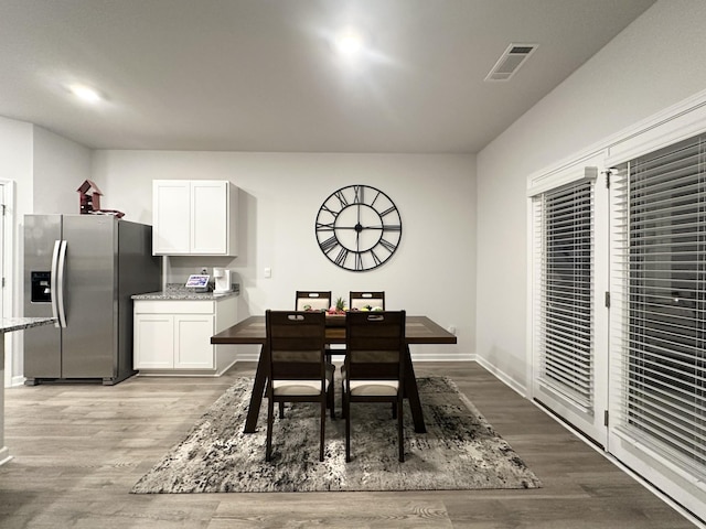 dining space with light wood finished floors, baseboards, and visible vents