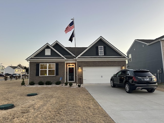 view of front of property featuring a garage, driveway, brick siding, and a front yard