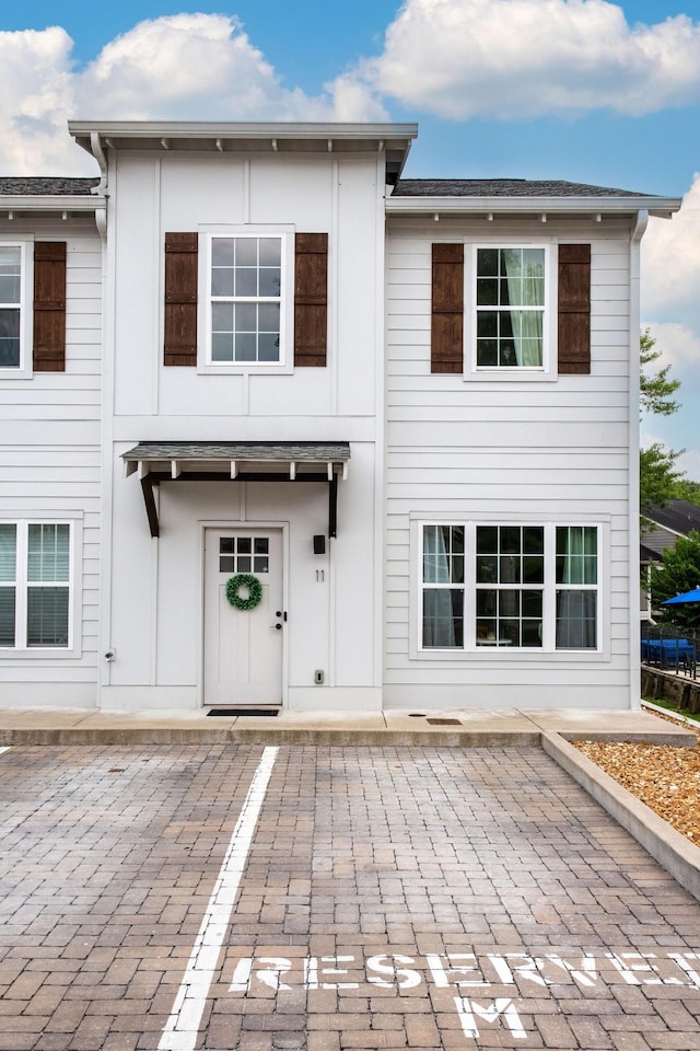 back of house with uncovered parking and a patio